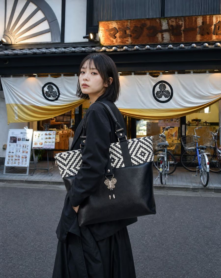 Sac noir à motifs géométriques, porté