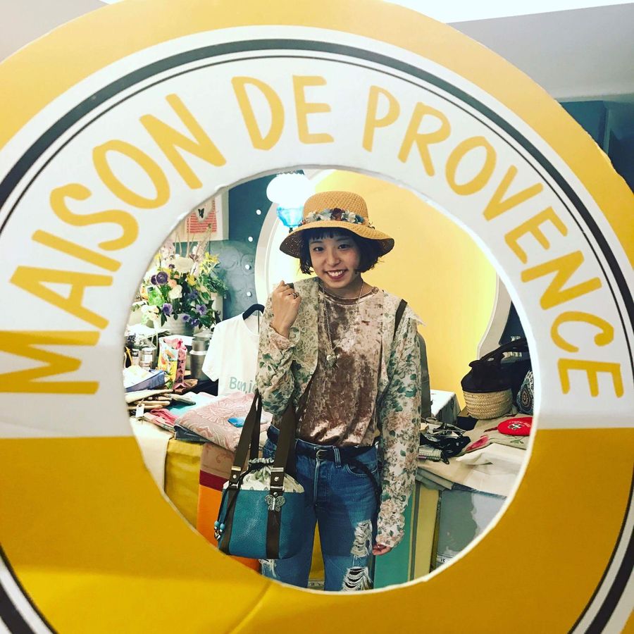 Cliente portant un sac Comme les Papillons dans le photocall Maison de Provence